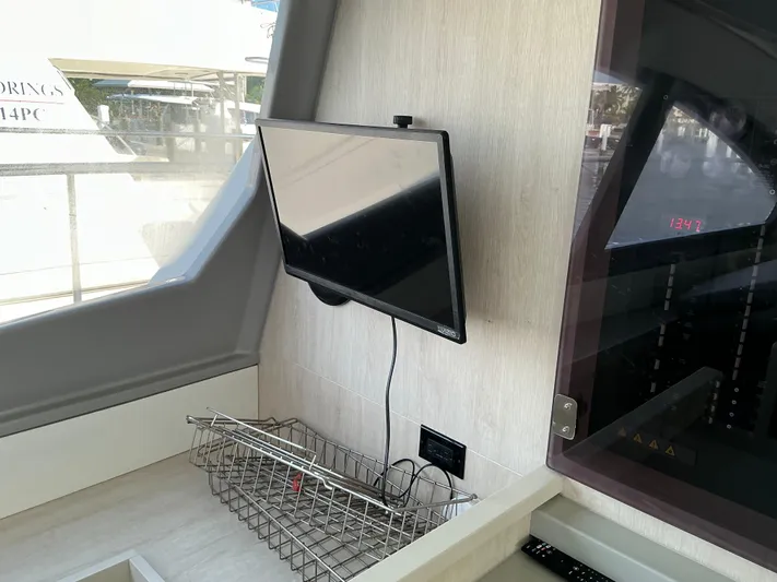 The Dance Yacht Photos Pics Interior of 2019 Leopard 51 Powercat with mounted TV and storage basket.