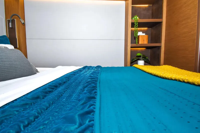  Yacht Photos Pics Luxurious bedroom interior on 2021 Lagoon 50 yacht with vibrant teal and yellow bedding.