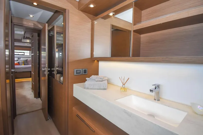  Yacht Photos Pics Luxurious bathroom interior on 2021 Lagoon 50 yacht, featuring modern sink and wooden cabinetry.