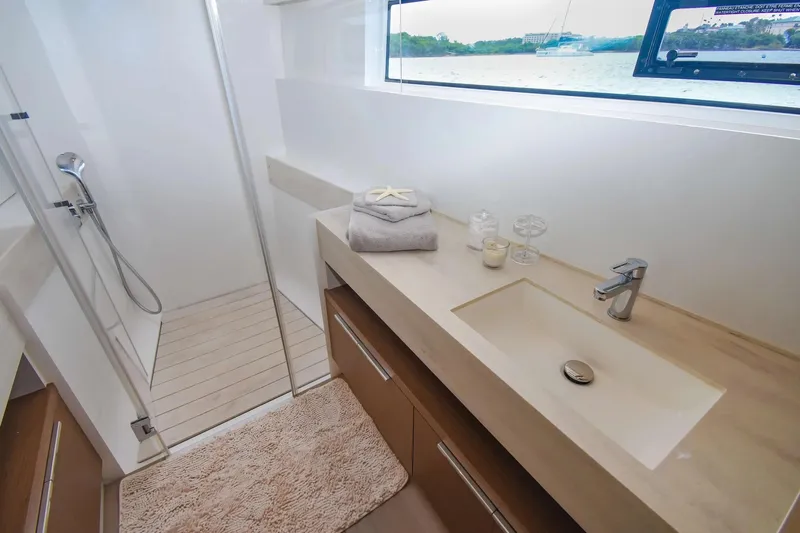  Yacht Photos Pics Luxurious bathroom in 2021 Lagoon 50 yacht with modern fixtures and scenic window view.