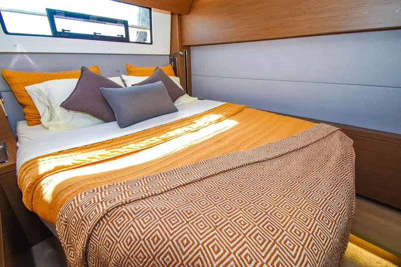  Yacht Photos Pics Luxurious cabin interior of 2021 Lagoon 50 yacht with cozy bedding and modern design.