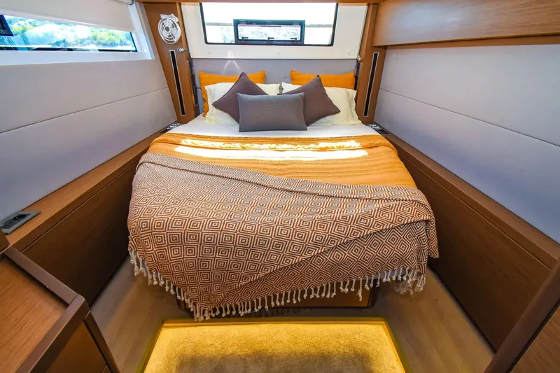  Yacht Photos Pics Luxurious bedroom interior of 2021 Lagoon 50 yacht with cozy bedding and modern design.