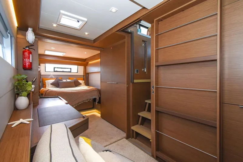  Yacht Photos Pics Luxurious interior of 2021 Lagoon 50 yacht with cozy bedroom and modern wood finishes.