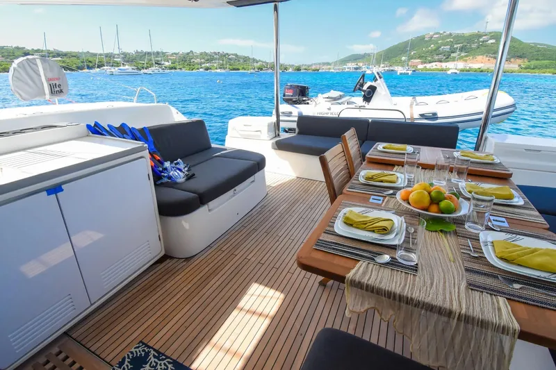  Yacht Photos Pics Luxurious 2021 Lagoon 50 yacht deck with dining setup, overlooking serene blue waters.