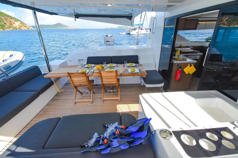  Yacht Photos Pics Luxurious Lagoon 50 catamaran deck with dining setup, ocean view, and snorkeling gear.
