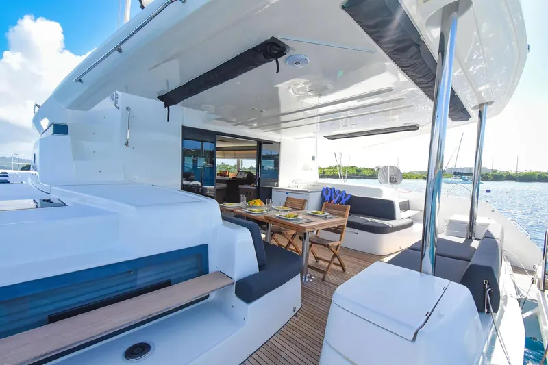  Yacht Photos Pics Luxurious 2021 Lagoon 50 catamaran with elegant outdoor dining area and scenic ocean view.