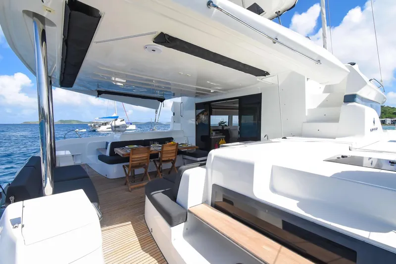  Yacht Photos Pics Luxurious 2021 Lagoon 50 yacht with spacious deck and dining area, anchored in serene waters.