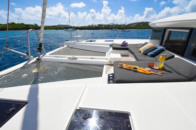  Yacht Photos Pics Luxurious 2021 Lagoon 50 catamaran deck with comfortable seating and scenic ocean view.