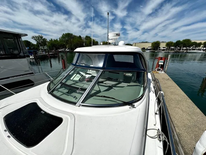  Yacht Photos Pics 2010 Sea Ray 40 Sundancer docked, featuring sleek design and panoramic windows under a vibrant sky.