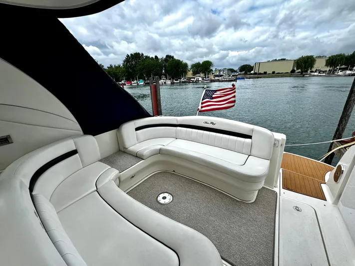  Yacht Photos Pics 2010 Sea Ray 40 Sundancer yacht with American flag, docked by a serene waterfront.