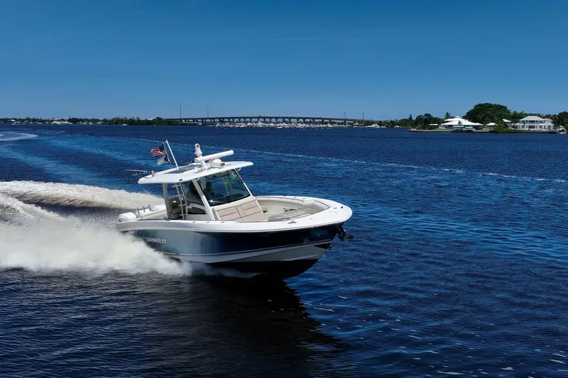 Crushed It Yacht Photos Pics 2018 Boston Whaler 380 Outrage cruising on a sunny day, with scenic waterfront backdrop.