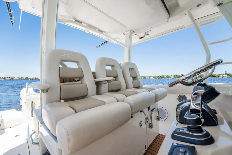 Crushed It Yacht Photos Pics 2018 Boston Whaler 380 Outrage helm with luxurious seating and controls, overlooking serene waters.