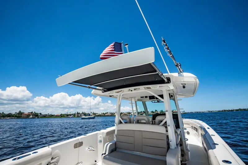 Crushed It Yacht Photos Pics 2018 Boston Whaler 380 Outrage boat on water, clear sky, American flag flying.