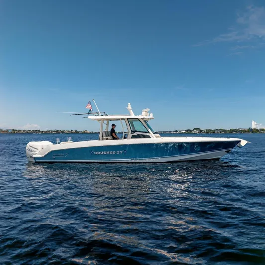 Crushed It Yacht Photos Pics 2018 Boston Whaler 380 Outrage boat on water, side view, with American flag.