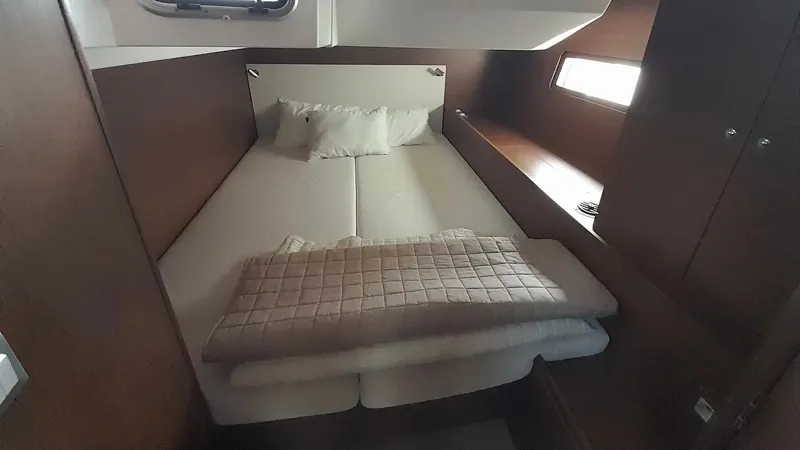 1725 Yacht Photos Pics Cozy cabin interior of 2022 Beneteau Oceanis 51.1 yacht with bed and window.