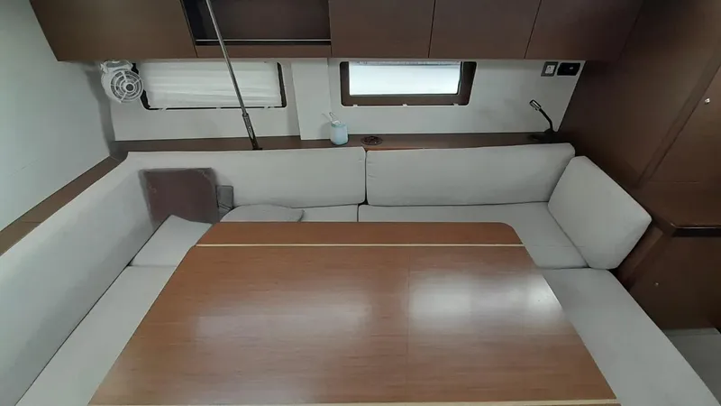 1725 Yacht Photos Pics Interior of 2022 Beneteau Oceanis 51.1 yacht with cozy seating and wooden table.
