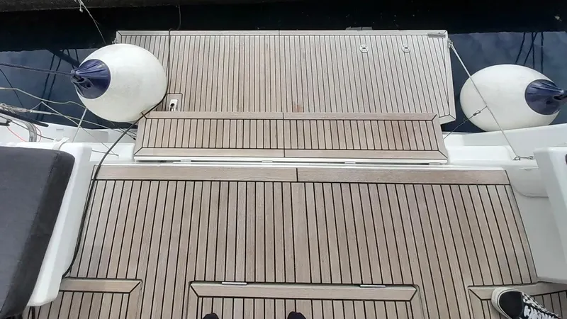 1725 Yacht Photos Pics Teak deck of 2022 Beneteau Oceanis 51.1 yacht with fenders and water view.