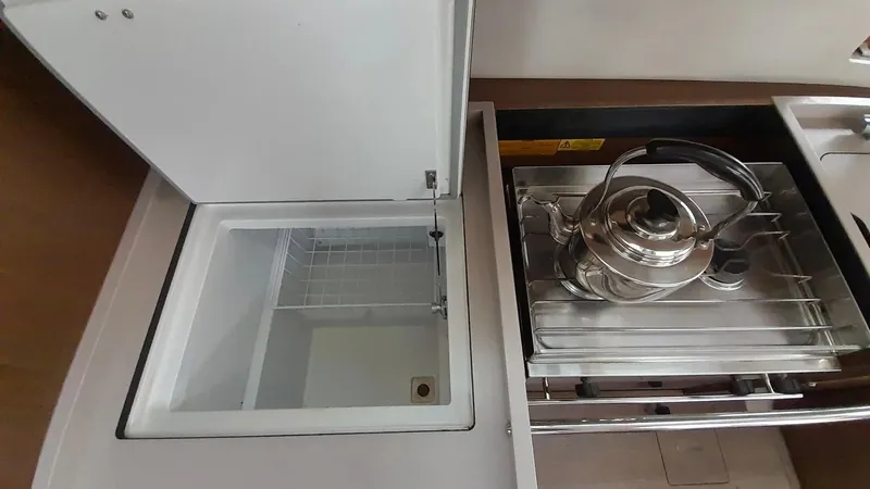 1725 Yacht Photos Pics Interior of 2022 Beneteau Oceanis 51.1 yacht kitchen with stove and open fridge.