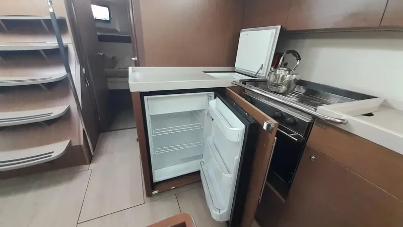 1725 Yacht Photos Pics Interior of 2022 Beneteau Oceanis 51.1 yacht kitchen with open fridge and modern amenities.