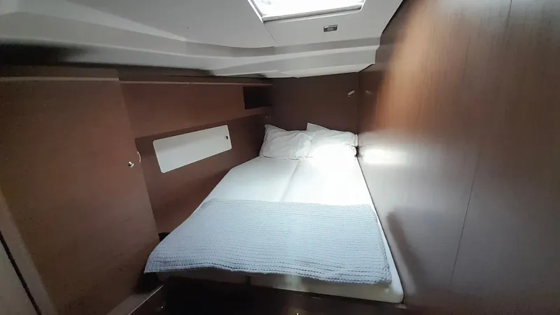 1725 Yacht Photos Pics Cozy cabin interior of 2022 Beneteau Oceanis 51.1 yacht with bed and skylight.