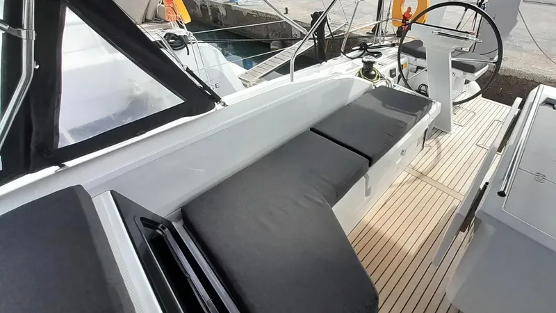 1725 Yacht Photos Pics 2022 Beneteau Oceanis 51.1 yacht cockpit with cushioned seating and steering wheel.