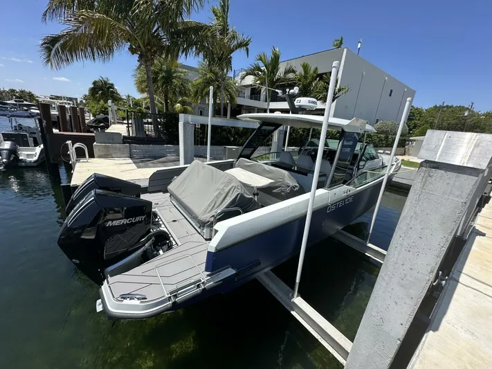 Ostende Yacht Photos Pics 2022 Saxdor 320 GTO boat docked with twin Mercury engines, surrounded by palm trees.