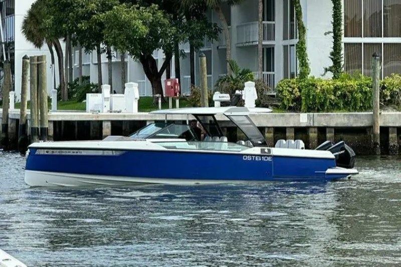  Yacht Photos Pics 2022 Saxdor 320 GTO boat cruising near a waterfront property.