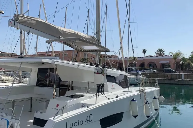  Yacht Photos Pics 2019 Fountaine Pajot Lucia 40 catamaran docked in a marina, sunny day.