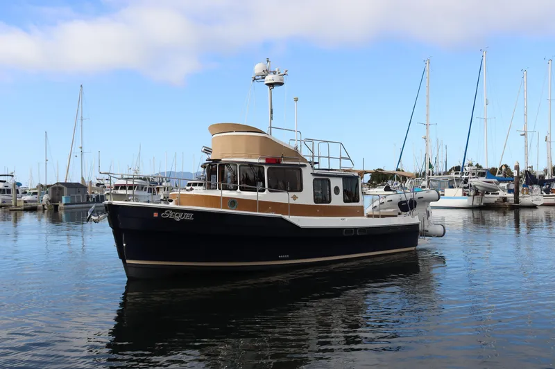 Sequel Yacht Photos Pics 2015 Ranger Tugs R-31 CB boat docked in a marina with sailboats.