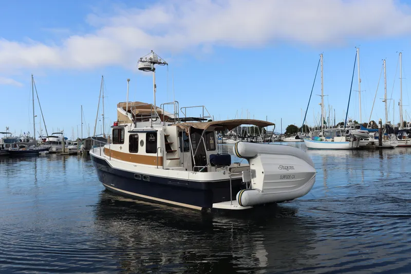 Sequel Yacht Photos Pics 2015 Ranger Tugs R-31 CB boat docked in a marina, clear sky background.