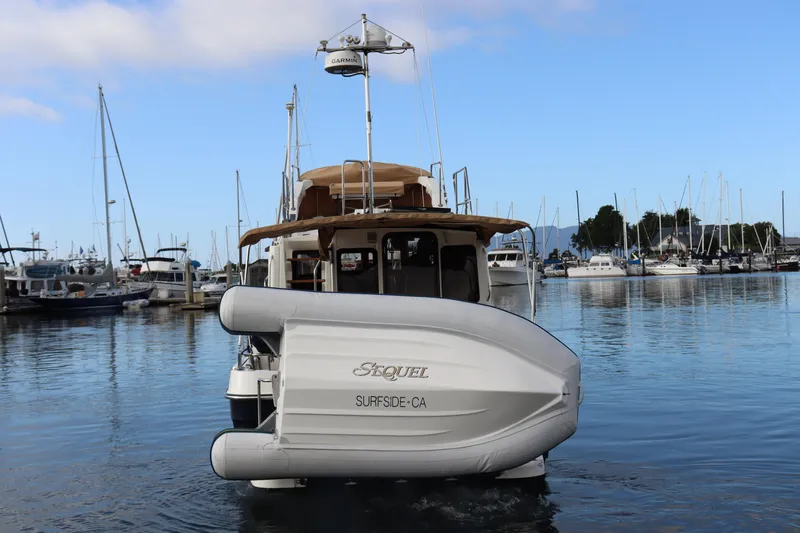 Sequel Yacht Photos Pics 2015 Ranger Tugs R-31 CB boat docked in marina, rear view with inflatable dinghy.