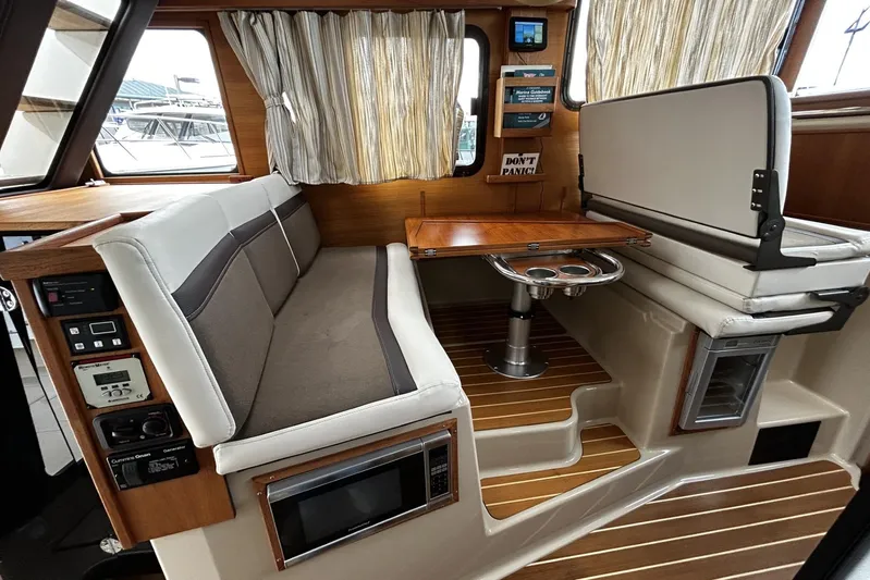 Sequel Yacht Photos Pics 2015 Ranger Tugs R-31 CB interior with seating, table, and control panel.