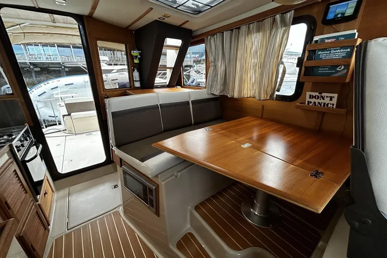 Sequel Yacht Photos Pics 2015 Ranger Tugs R-31 CB interior with dining area and wooden table.