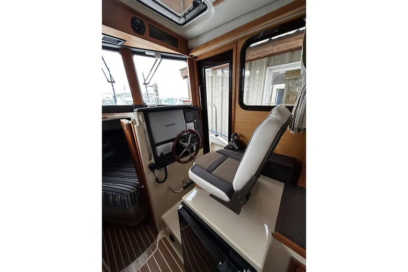 Sequel Yacht Photos Pics Interior of 2015 Ranger Tugs R-31 CB with helm, Garmin display, and captain's chair.