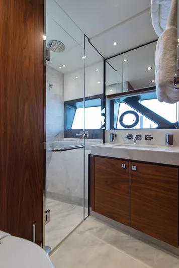  Yacht Photos Pics Luxurious bathroom in 2020 Sunseeker 76 Yacht with wood cabinetry and glass shower.