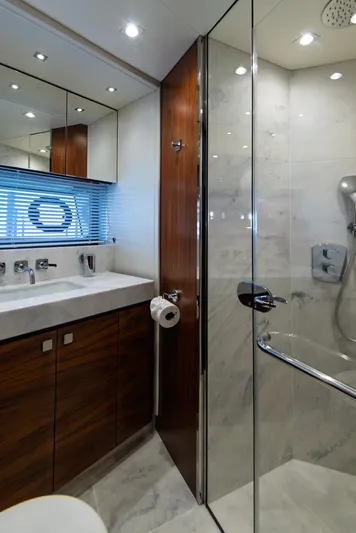 Yacht Photos Pics Luxurious bathroom in 2020 Sunseeker 76 Yacht with modern fixtures and glass shower.