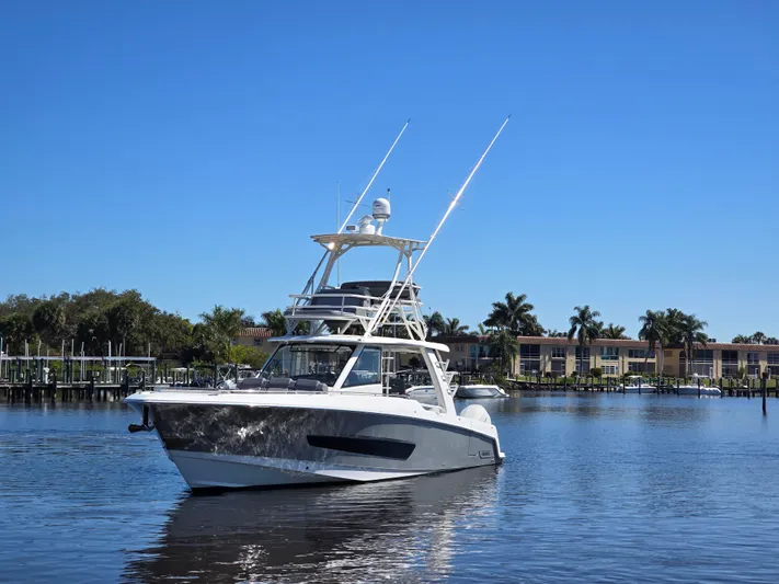  Yacht Photos Pics Boston Whaler 420 Outrage 2023 on calm water with palm trees.