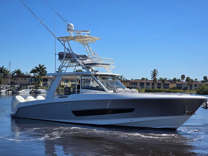  Yacht Photos Pics 2023 Boston Whaler 420 Outrage on calm water with palm trees.