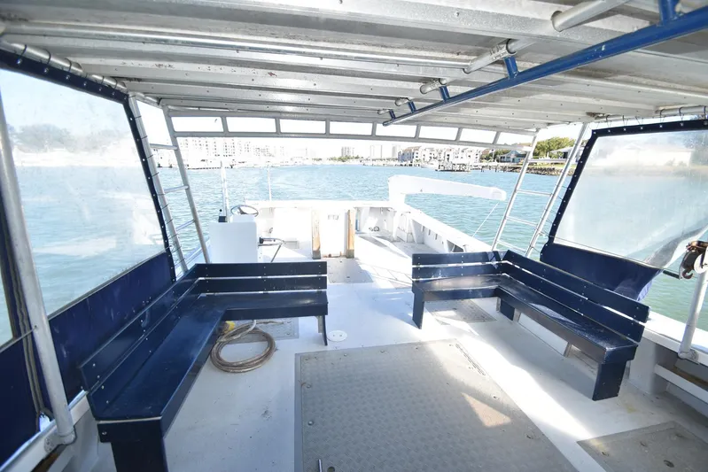 Ocean Explorer Yacht Photos Pics Interior view of 2006 Custom 45 Doucette boat with seating and waterfront backdrop.