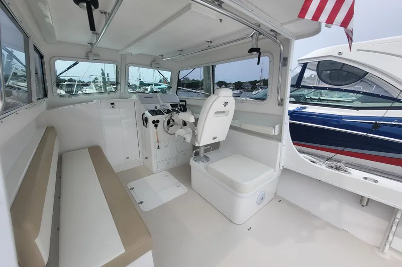  Yacht Photos Pics 2023 Steiger Craft 31 Fisherman interior with helm, seating, and American flag.