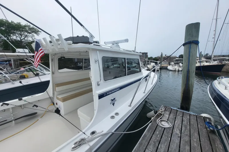  Yacht Photos Pics 2023 Steiger Craft 31 Fisherman docked at marina, featuring sleek design and American flag.