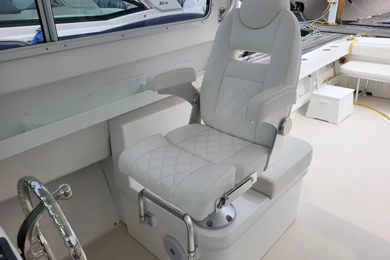  Yacht Photos Pics Captain's chair in 2023 Steiger Craft 31 Fisherman boat, featuring white upholstery and modern design.