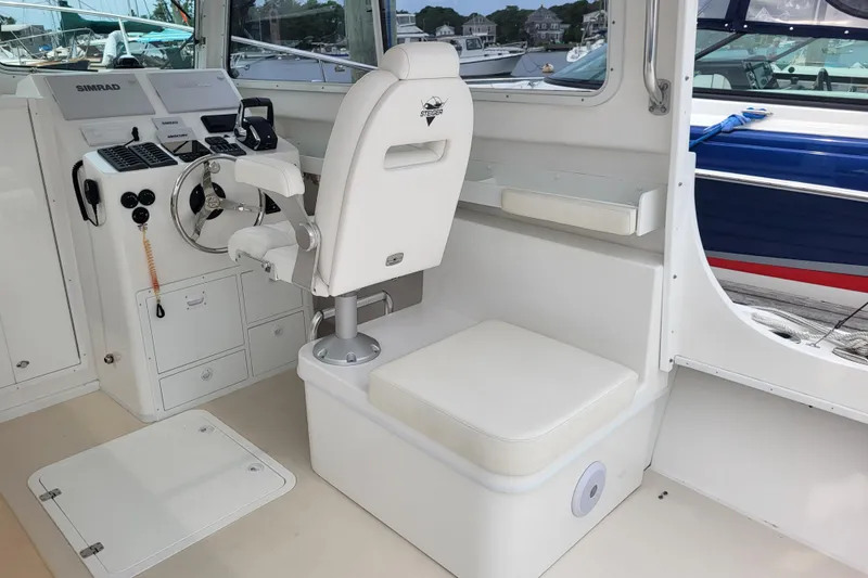  Yacht Photos Pics 2023 Steiger Craft 31 Fisherman boat interior with helm, steering wheel, and seating.