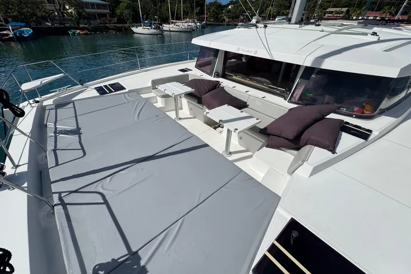 Raiatea Yacht Photos Pics Luxurious 2015 Bali 4.5 catamaran deck with seating and cushions, docked in a serene marina.