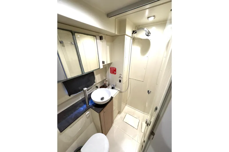 Raiatea Yacht Photos Pics Compact bathroom in 2015 Bali 4.5 yacht with shower, sink, and storage cabinets.