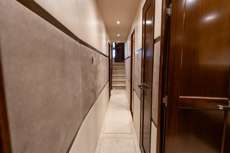 The Provider Yacht Photos Pics Hallway inside 2015 Viking 76 Convertible yacht with wooden doors and carpeted floor.