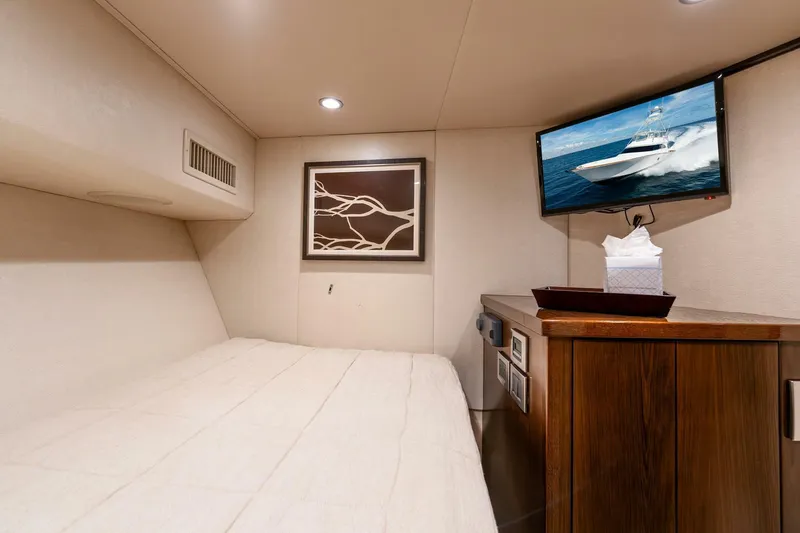 The Provider Yacht Photos Pics Cozy cabin interior of 2015 Viking 76 Convertible yacht with bed, TV, and artwork.