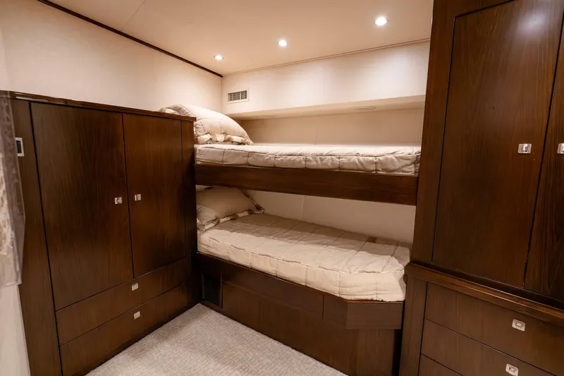 The Provider Yacht Photos Pics Interior of 2015 Viking 76 Convertible yacht with cozy bunk beds and wooden cabinetry.