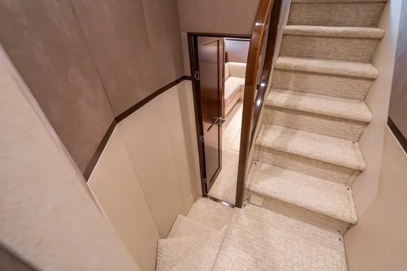 The Provider Yacht Photos Pics Interior staircase of 2015 Viking 76 Convertible yacht, featuring carpeted steps and wooden accents.