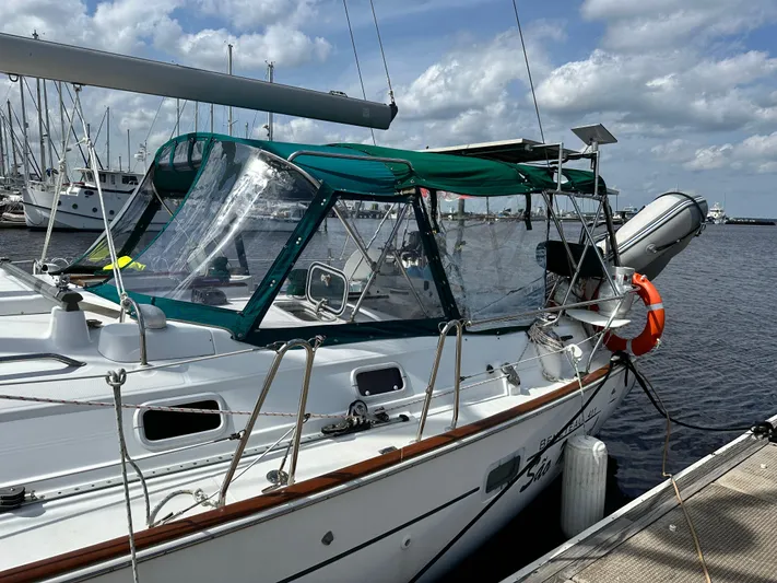 Sao Miguel Yacht Photos Pics Beneteau Oceanis 40 sailboat docked, 2000 model, with green canopy and lifebuoy.